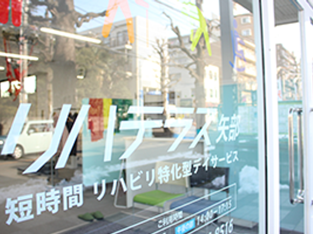 看板 看板 施設の看板が目を引くエントランスです。明るい雰囲気で、訪れる人を温かく迎えます。