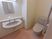 サムネイル 施設の写真 鏡と洗面台が設置されている、広々としたスペースがあるトイレ。清潔感がある白い壁には手すりが取り付けられている。