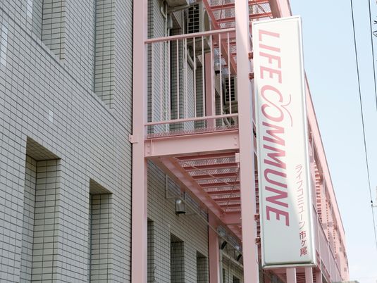 ピンクの外階段の建物