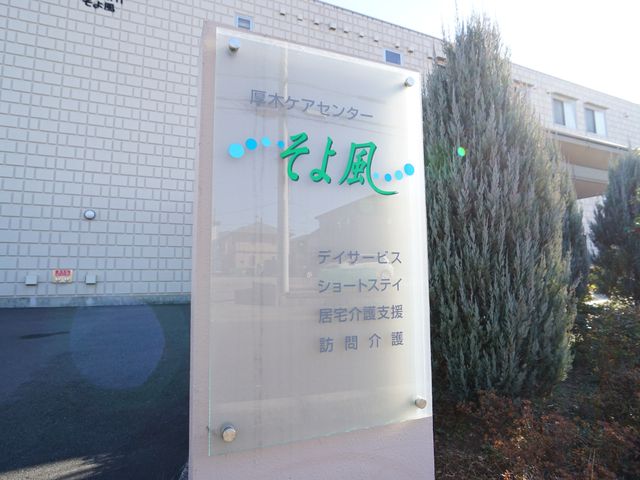施設看板のクローズアップ ロゴ 清潔感のある白壁に映える施設の看板が、訪れる人々を明るく迎え入れています。