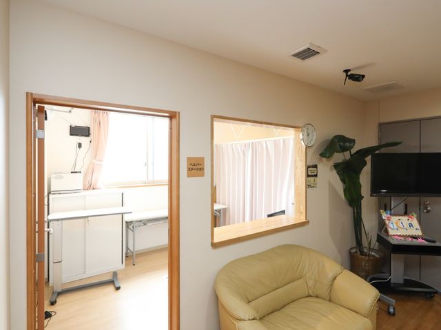 快適な居室の様子 ヘルパーステーション ゆったりとした居心地の良い居室です。必要な機能が整っており、明るい窓辺やリラックスできるソファが配置されています。