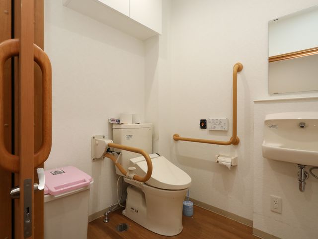 バリアフリー設計のトイレ トイレ 安全に配慮された手すりがついた清潔なトイレ空間です。利用者の自立支援に役立つ設備が整っております。