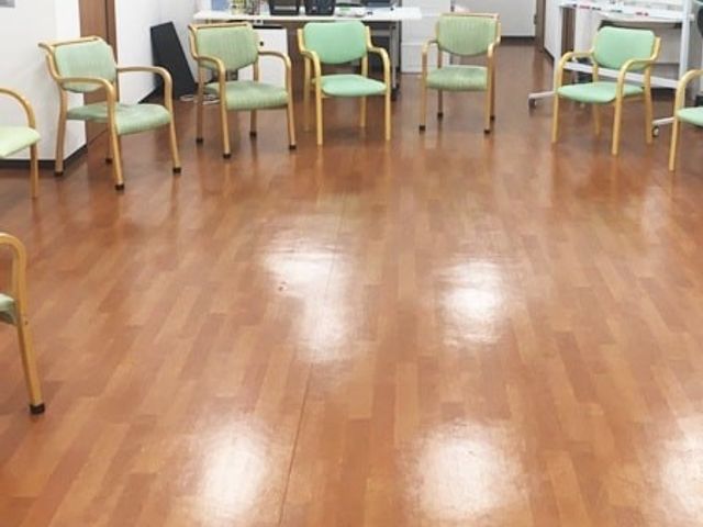 椅子が並ぶ多目的室 多目的室   明るい床の広い空間に椅子が並んでおり、集まりや体操などに使いやすそうです。人の動きが想像しやすく、働く場の雰囲気もつかみやすいです。