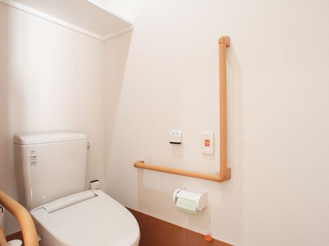 バリアフリーのトイレ設備 トイレ 手すり付きのトイレで、利用者の安全を考慮した設計です。利便性と快適さを提供する空間が整っています。