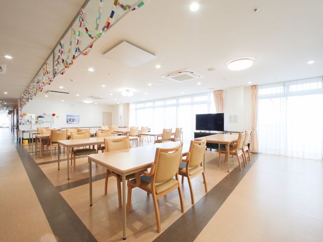広々とした明るい食堂 食堂 ゆとりある配置のテーブルと椅子が並ぶ、日差しの入る広々とした食堂です。共有スペースでくつろぎながら、コミュニケーションを楽しめる環境が整っています。