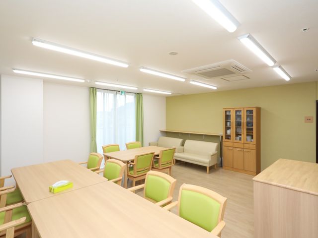緑の椅子が並ぶ明るい食堂 食堂 清潔で明るいダイニングルームです。心地よい色合いの椅子が配置され、ゆったりとした食事の時間を過ごせそうです。