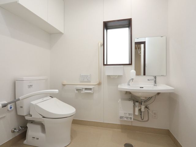 清潔な洗面トイレ空間 トイレ 洗練されたデザインの洗面台は使いやすさを考慮し、清潔感が保たれた状態です。安心して日常のケアが行えるように、手すりも設置されています。