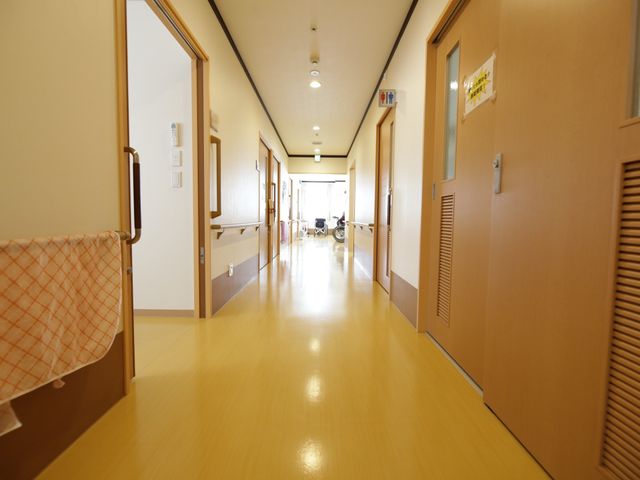 清潔感ある明るい廊下 廊下 ゆとりある廊下は足元にも配慮された設計で、快適な就業環境を提供しています。明るい色合いが心地良い空間を演出しています。