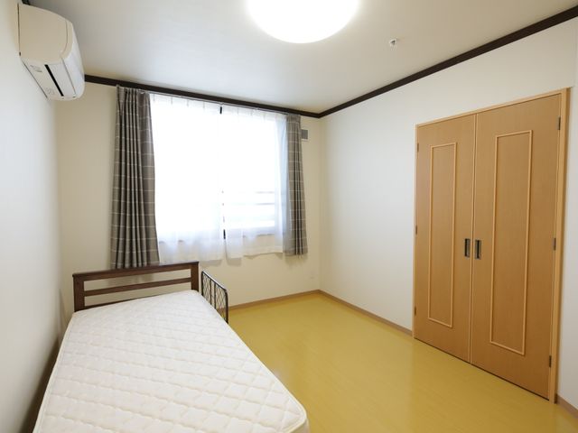 明るい居室の一例 居室 シンプルでモダンなデザインの居室です。個々のプライバシーを大切にしつつ、快適な空間を提供しています。