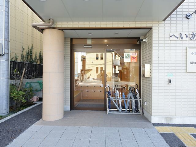 入口のある外観 玄関 広々としたエントランスは自然光が差し込み、訪れる方をやさしく迎え入れます。傘立ても完備され、細やかな配慮が感じられる空間です。