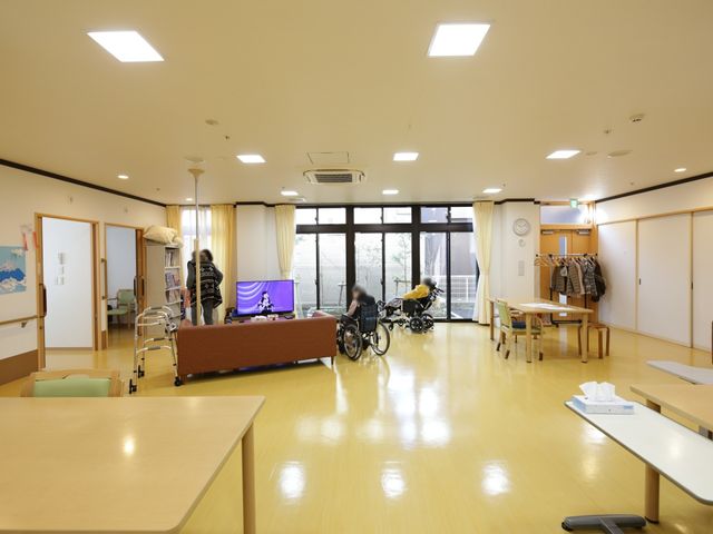 共用スペースの日常風景 休憩スペース 開放的で明るいラウンジで、利用者の方々がテレビを鑑賞されています。賑やかな交流の場として、日々の憩いのひとときを提供しています。