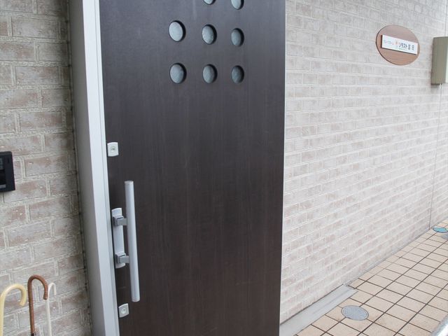ダークブラウンの扉 玄関 デザイン性のあるエントランスの扉です。複数の円形がデザインされ、心地よい印象を与えています。