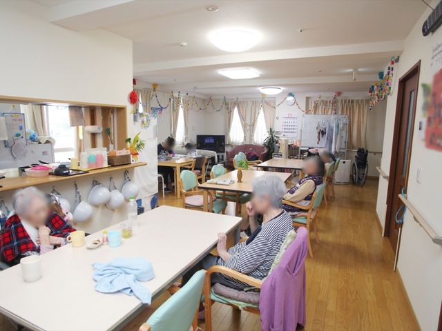 共有エリアの過ごしやすい日常 共有ダイニング 居心地の良い食堂で、利用者がお茶を楽しんでいます。落ち着いた雰囲気の中で日々の交流が生まれる空間です。