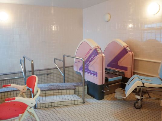 広い浴室内に大きな浴槽がある。浴槽の前には階段があり、両脇に手摺を設置している。座った状態でも入浴できる機械もある。