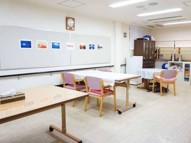 多目的スペースの風景 食堂 広々とした明るい多目的スペースが、日々の交流や活動に役立っています。椅子やテーブルが配置され、快適な時間を過ごすことができそうです。