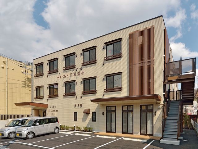 3階建ての建物外観 外観 広々とした駐車スペースを備えた施設です。洗練されたデザインが特徴的です。