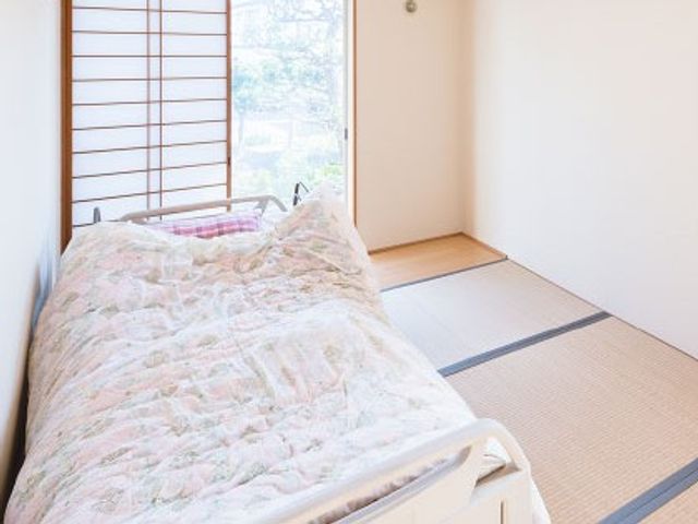 畳敷きの居室 居室   窓から光が入る、和室の落ち着いた居室です。ベッドと畳の両方があり、くつろぎやすい空間に見えます。