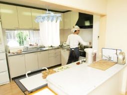 明るいキッチンと作業中の人