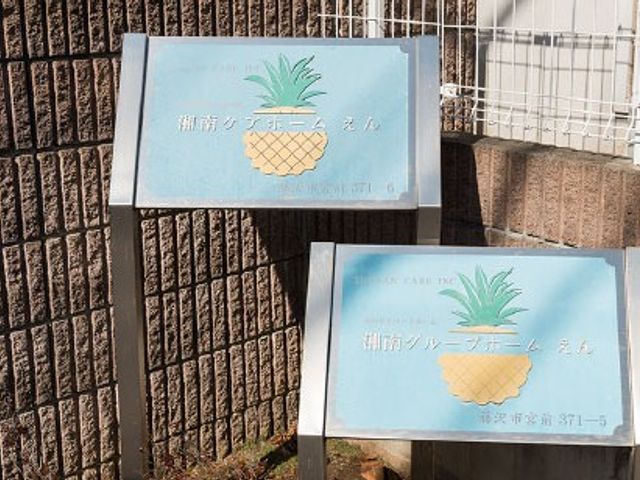 看板がある外観 看板   建物の外に、青い看板が2つ設置されています。施設名が見え、訪れる方に場所を案内しやすい印象です。