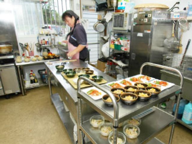 調理中のキッチン キッチン 明るいキッチンで、スタッフが食事の準備をしています。整理された調理スペースが特徴です。
