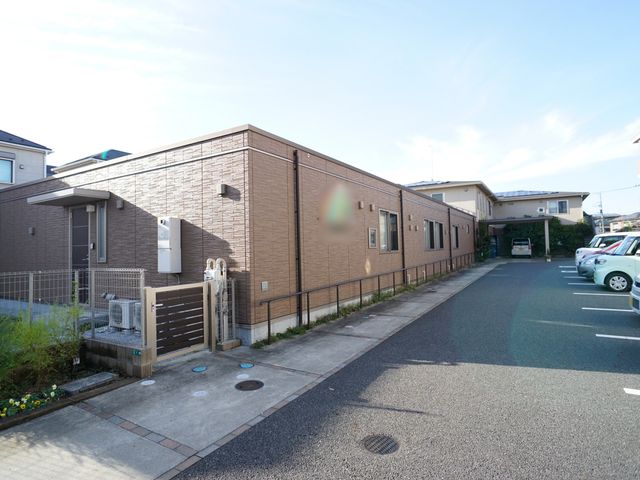茶色の壁の建物外観 外観 落ち着いた色合いの建物は、住宅街に溶け込むデザインです。広々とした駐車スペースがあり、来訪がしやすい環境が整っています。