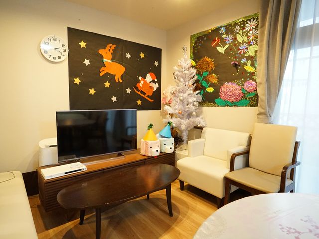 リビングの装飾と家具 共有スペース 季節感あふれる装飾と、ソファが配置された落ち着いた雰囲気のリビングです。共有スペースでの憩いの時間をご提供します。