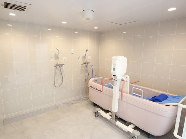 清潔な浴室と設備 機械浴 清掃が行き届いており、リフト付きのバスタブが装備された快適な浴室です。利用者の安全と快適性が考慮された設計になっています。