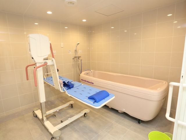 バリアフリー浴室設備 機械浴室 安全に配慮された設計の浴室です。移乗リフトと手すりが支援を容易にし、利用者の快適な入浴をサポートします。