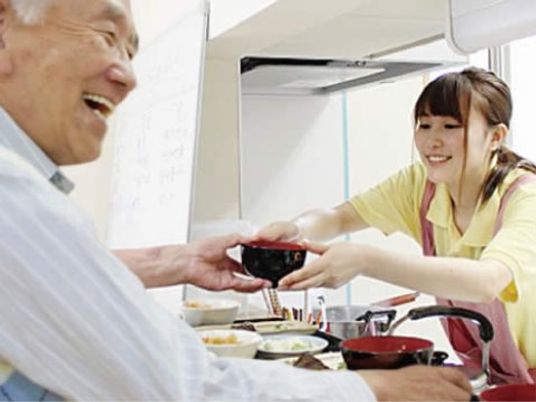 笑顔で食事介助する場面