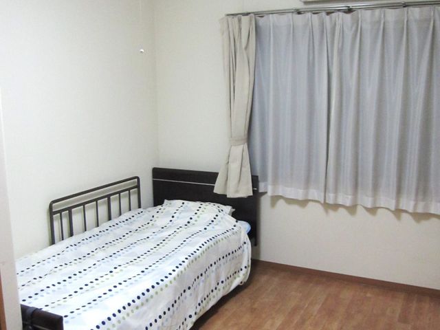 居室のベッドと窓 居室 シンプルで落ち着いた居室です。自然光が入り、快適に過ごせる空間が整っています。