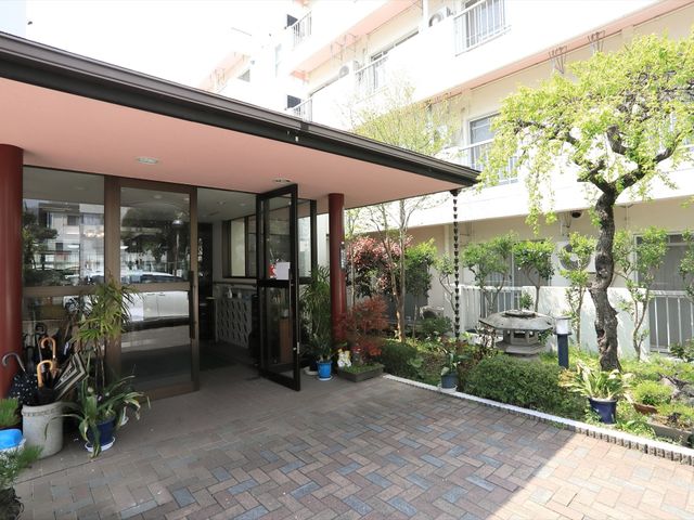 エントランスと中庭の風景 玄関 明るく開放的な入口が迎えるエントランスです。緑豊かな中庭も見渡せ、穏やかな雰囲気が感じられます。