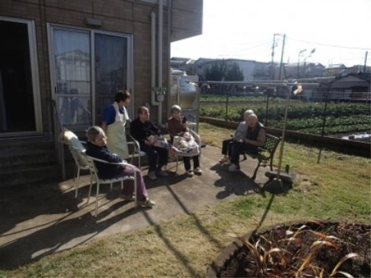 温かな雰囲気の庭で職員と利用者