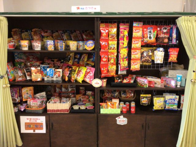 たくさんの食品が並ぶ棚 多目的室 豊富なお菓子や食品が並ぶスペースです。日常生活に必要なものが揃い、便利に利用できます。
