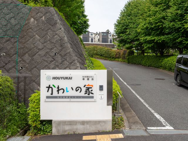 施設の看板と周辺 看板 施設名を表示した看板が道路脇に設置されています。訪れる人に分かりやすい目印です。