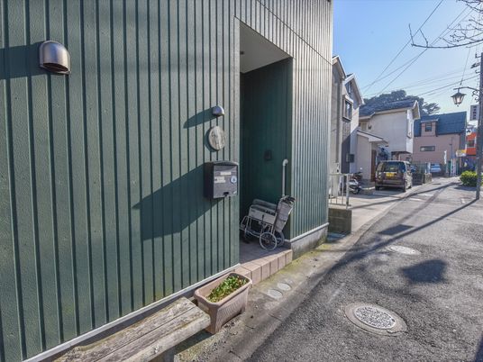 外観の緑色の壁と車椅子