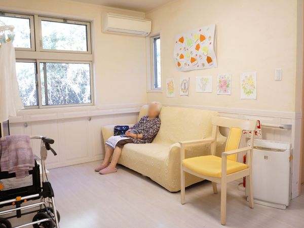 明るい部屋とソファの人物