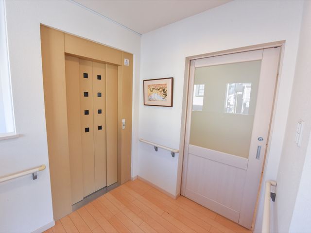 エレベーターとガラス扉の廊下 エレベーター 手すり付きの廊下には明るく開放的なガラス扉とエレベーターが設けられ、安全かつ快適に移動できる設計です。