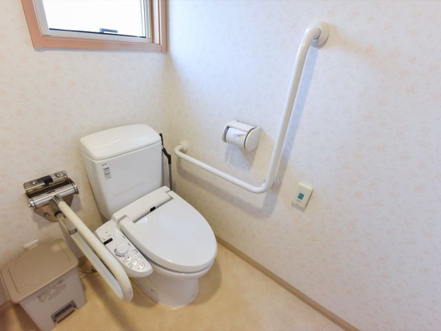 バリアフリートイレ設備 トイレ 手すり付きの安全なトイレです。利用者の自立支援と安全を考慮した設計になっています。