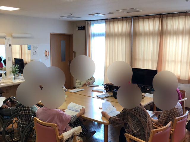 居室で過ごす人々 行事 広々とした空間で、皆さんが談笑しながら楽しげに過ごしています。安定した椅子が配置され、ゆったりとした日常生活を支援しています。