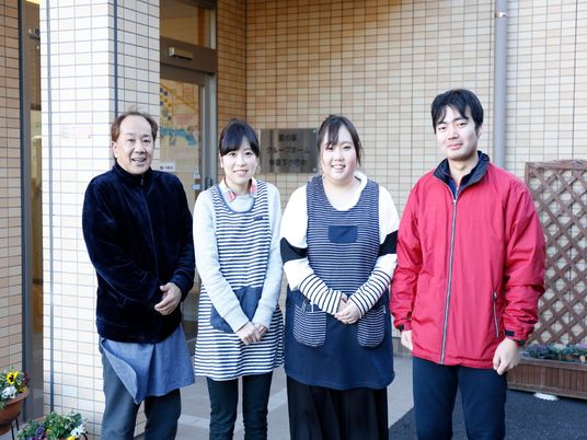 施設前で笑顔のスタッフ