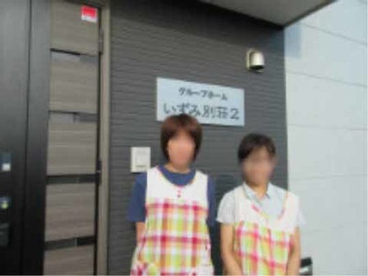 スタッフ立つシャッター前