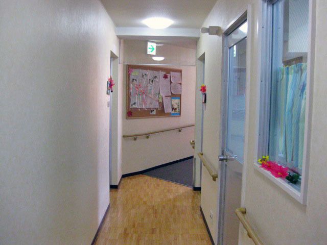 廊下の明るい様子 廊下 清潔感のあふれる廊下の突き当りに掲示物が見えます。壁には季節の飾りつけがされ、温かみのある雰囲気です。