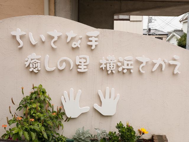手と花の彩る看板 看板 手に花を添えた暖かな看板です。訪れる方々を優しい手振りで迎え入れ、温もりを感じる空間へと導いています。