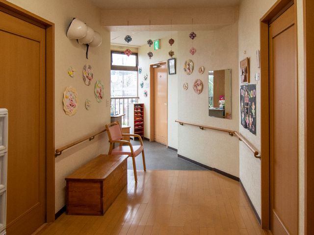 廊下に手すりと椅子 廊下 暖かみのある廊下には手すりと休憩できる椅子が設置されています。