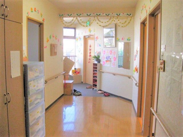 明るい廊下の様子 玄関 手作りの壁飾りが心温まる通路です。日差しが差し込む廊下は清潔感があります。