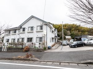 白い壁の建物と駐車場