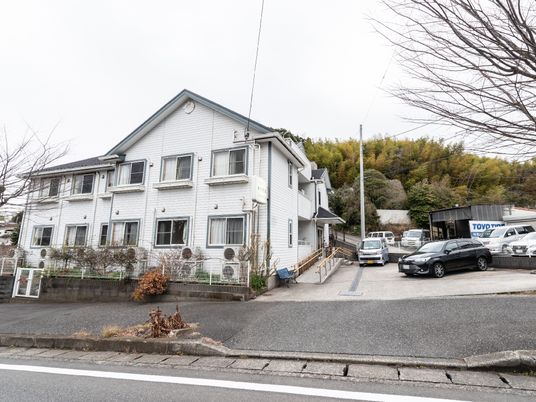 白い壁の建物と駐車場