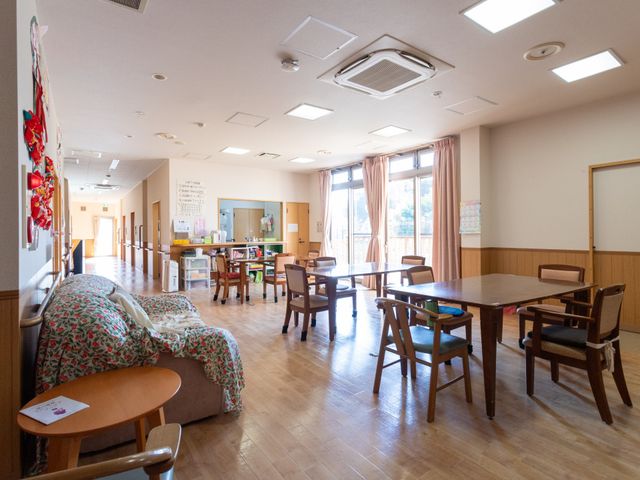 広々とした明るいリビング リビング 自然光が差し込む広々とした空間で、住人の方々が快適にくつろげる場となっています。テーブルや椅子が配置され、交流の場として利用されます。