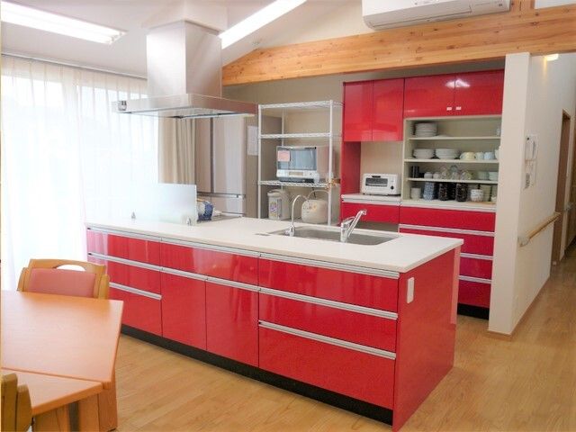 赤いキッチンのある居室 キッチン 明るい色彩のキッチンが心地よい居室で、清潔感が漂います。