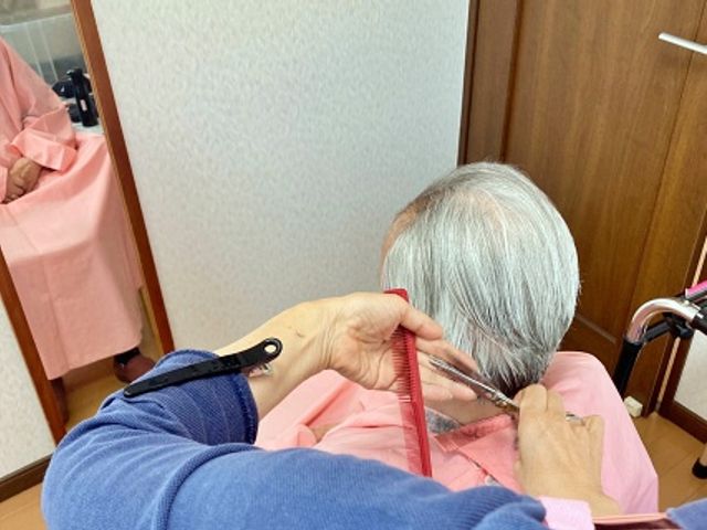 髪を整える様子の理美容室 理美容室 居心地の良さを感じる空間で、リラックスしながら美容サービスが受けられます。楽しい会話を添えて。